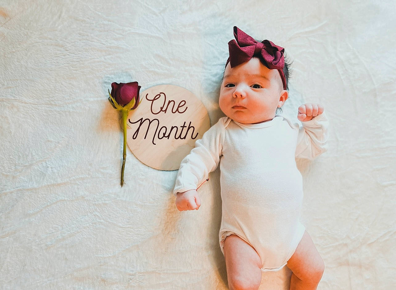 Jhene is registered to the contest to win money with this photo: arm, baby, baby_toddler_clothing, chest, child, fashion_accessory, finger, happy, headgear, human_leg, nail, pattern, person, pink, skin, sleeve, textile, thigh, thumb, toddler