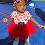 Judea joined the competition — help win amazing prizes! toddler, child, red_tutu, headband, strawberry_pattern, white_shoes, outdoor, inflatable_play_structure, blue_tarp, sunlight, shadow, curious_expression, clothing, footwear, playground, person, cute, young_child, summer, daylight