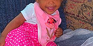 Judea is registered to the contest to win money with this photo: baby, child, pink_headband, pink_pants, polka_dot, smile, indoor, blanket, couch, bib, cozy, happy, infant, footwear, sitting, cute, person, portrait, toddler, clothing