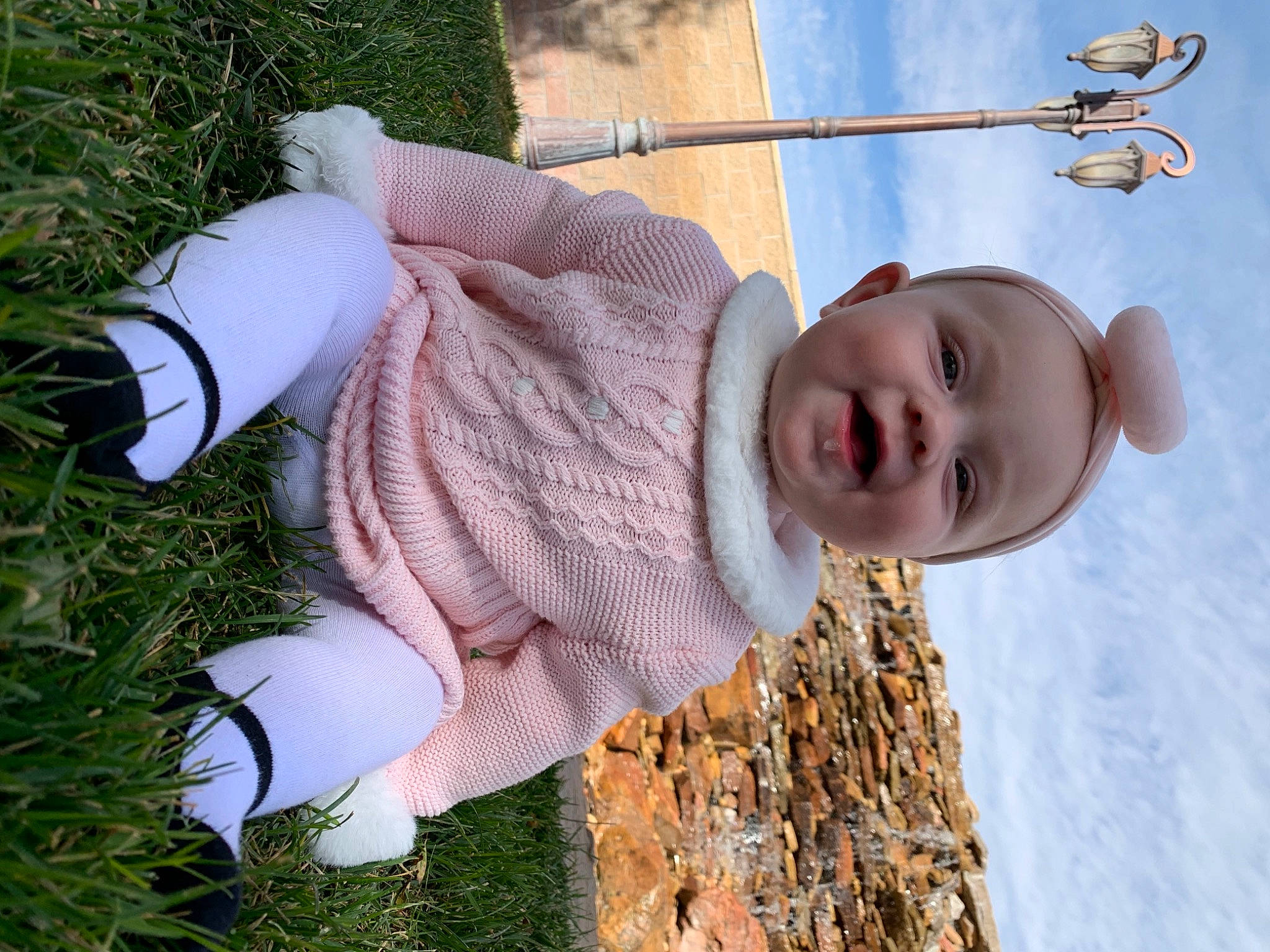 Annalynn is registered to the contest to win money with this photo: baby, baby_toddler_clothing, child, finger, fun, grass, grass_family, happy, headgear, human_body, leisure, pattern, people_in_nature, person, plant, sitting, sky, smile, toddler, tree