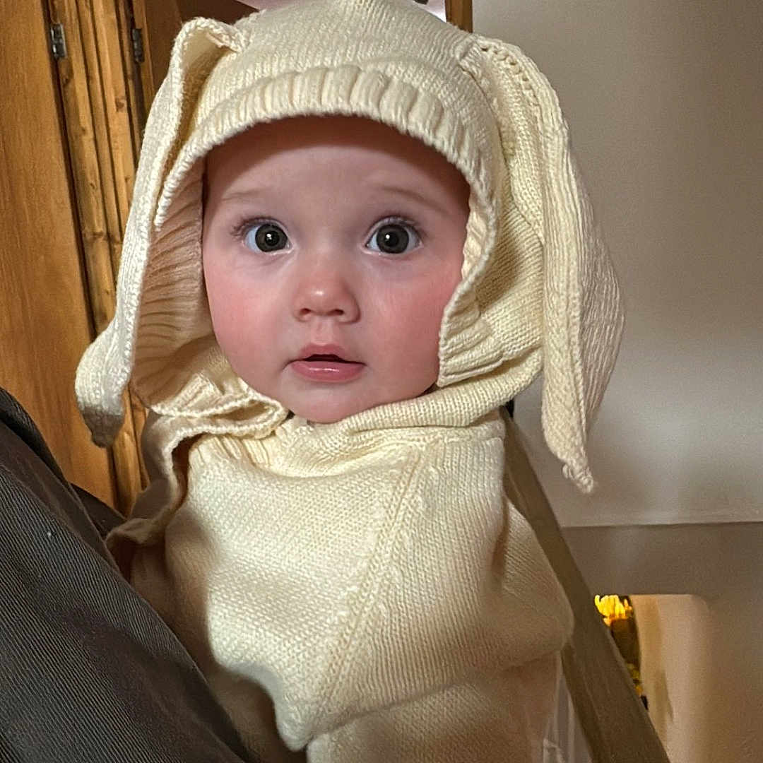 Orla is registered to the contest to win money with this photo: architecture, baby, bonnet, building, cap, clothing, coat, costume, face, hat, head, hood, house, housing, knitwear, person, photography, portrait, staircase, sweater