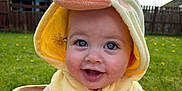 Cody joined the competition — help win amazing prizes! baby, child, costume, yellow, duck, hood, smiling, blue_eyes, flower, basket, outdoor, grass, dandelion, fence, cloudy_sky, happy, cute, portrait, infant, sunlight