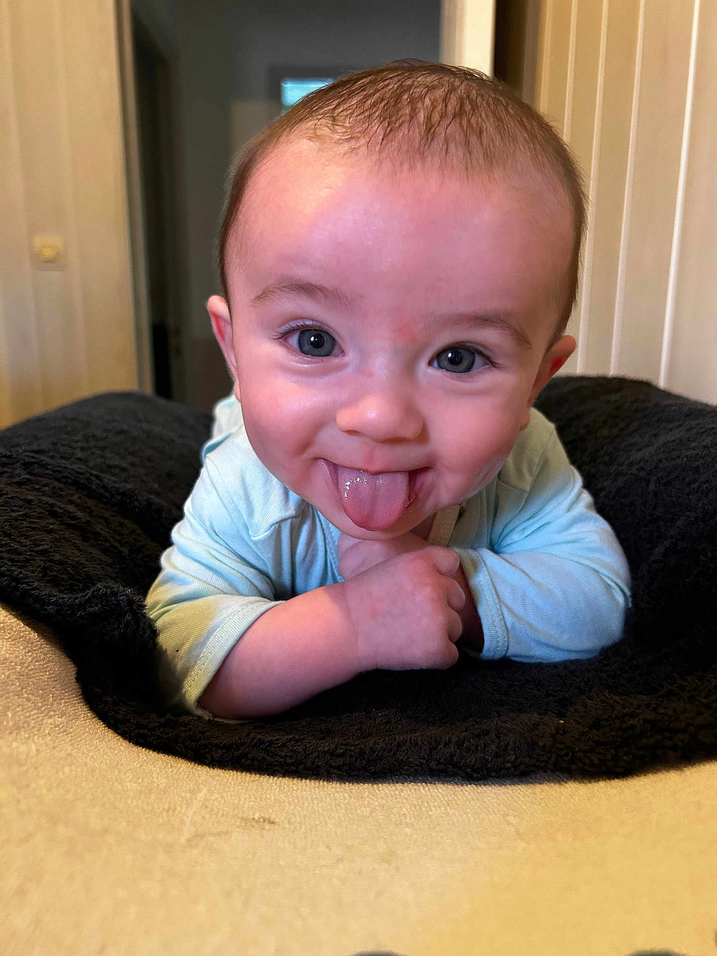Elyzio participe au concours pour gagner de l'argent avec cette photo : baby, infant, tongue_out, blue_eyes, smiling, cute, lying_down, blanket, indoor, child, face, skin, clothing, playful, expression, head, person, young_child, happy, portrait