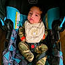 Nikolas joined the competition — help win amazing prizes! apparel, baby, bib, camouflage, car_seat, child, clothing, comfort, cute, fabric, face, indoors, infant, pattern, person, seatbelt, sitting, smile, text, young_child