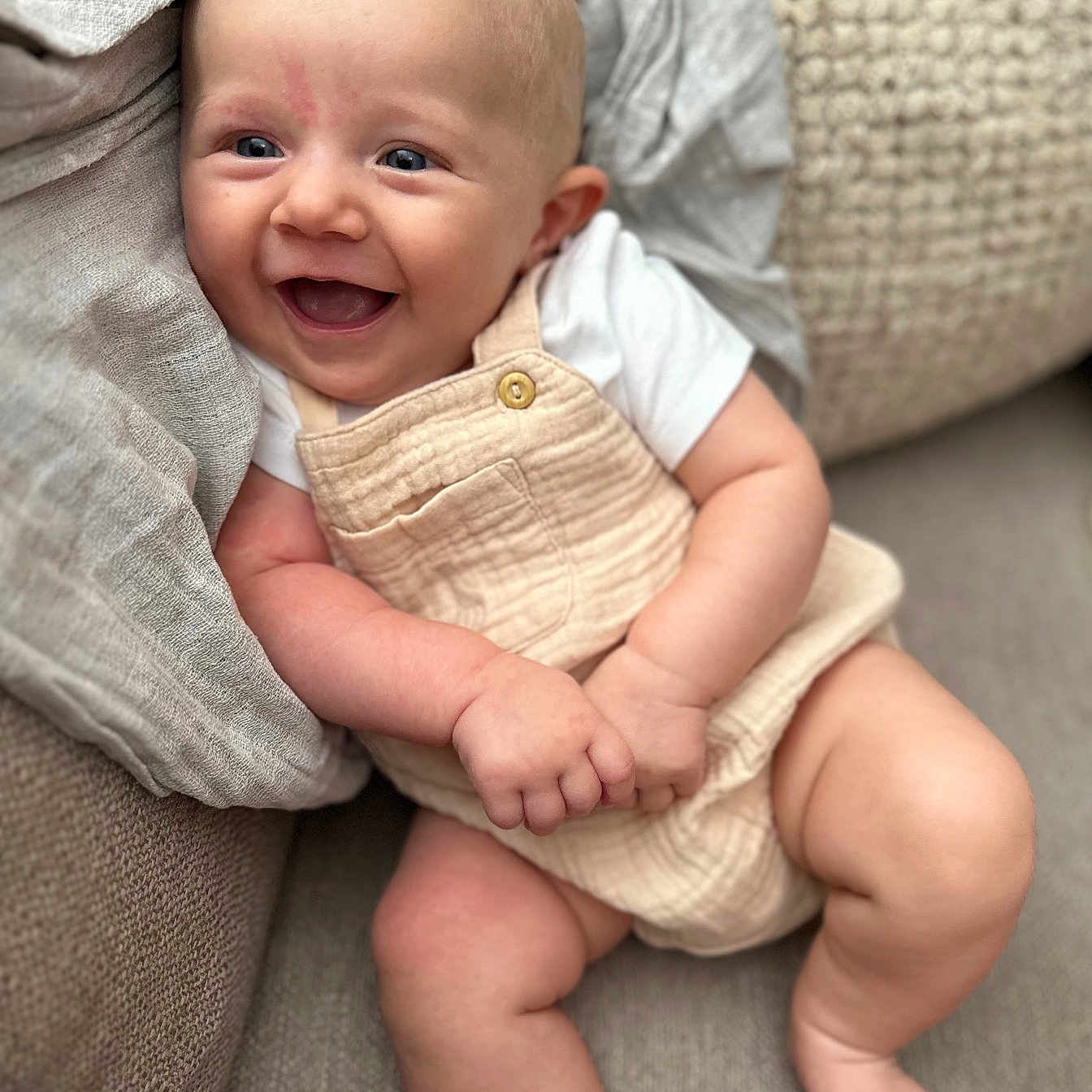Timéo participe au concours pour gagner de l'argent avec cette photo : baby, blanket, blue_eyes, clothing, comfort, couch, cute, face, foot, hands, happy, indoor, infant, legs, overalls, portrait, skin, smiling, soft_texture, white_shirt