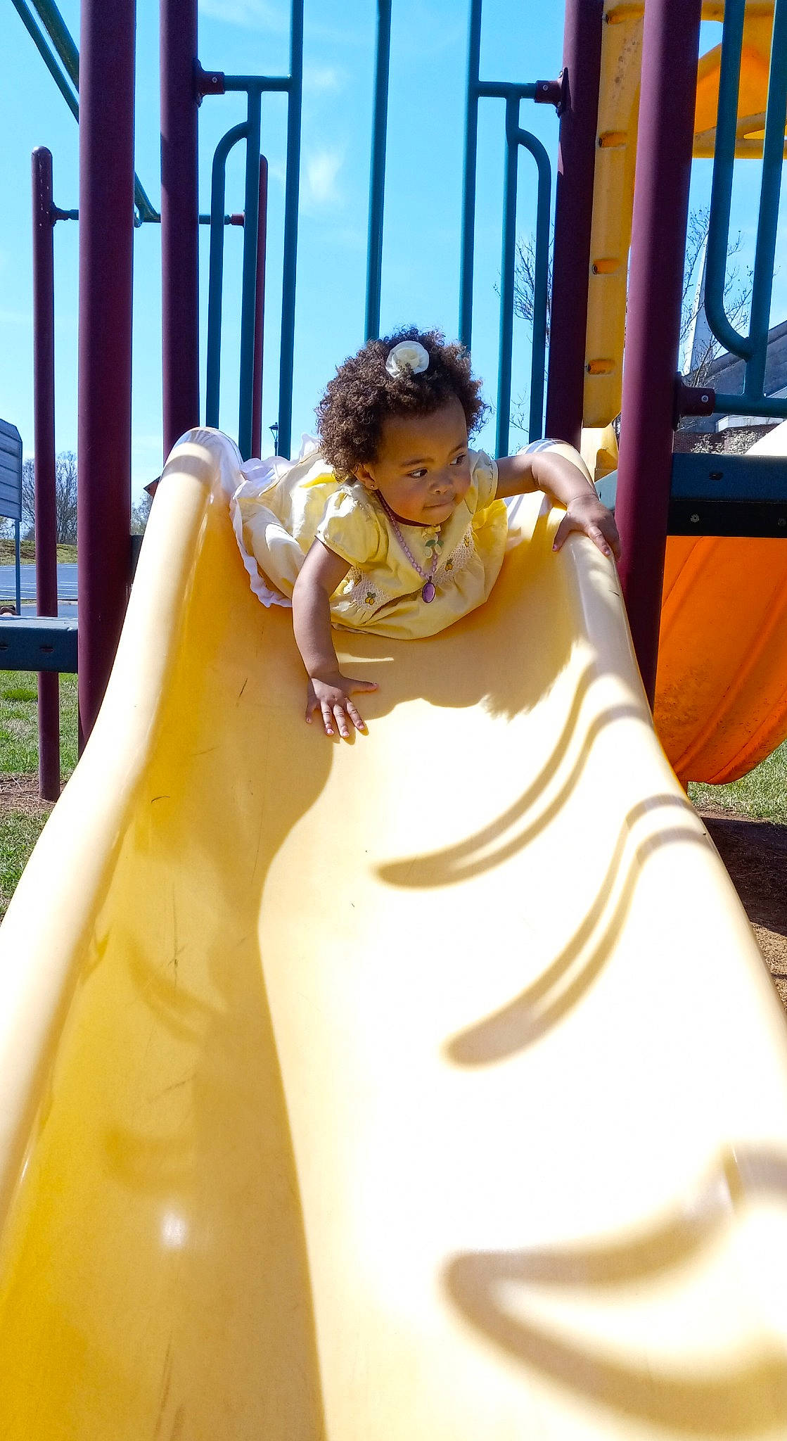 Araya is registered to the contest to win money with this photo: amusement_park, amusement_ride, child, chute, city, dress, fun, happy, leisure, nonbuilding_structure, outdoor_play_equipment, outdoor_recreation, person, plant, play, playground, playground_slide, recreation, sitting, sky