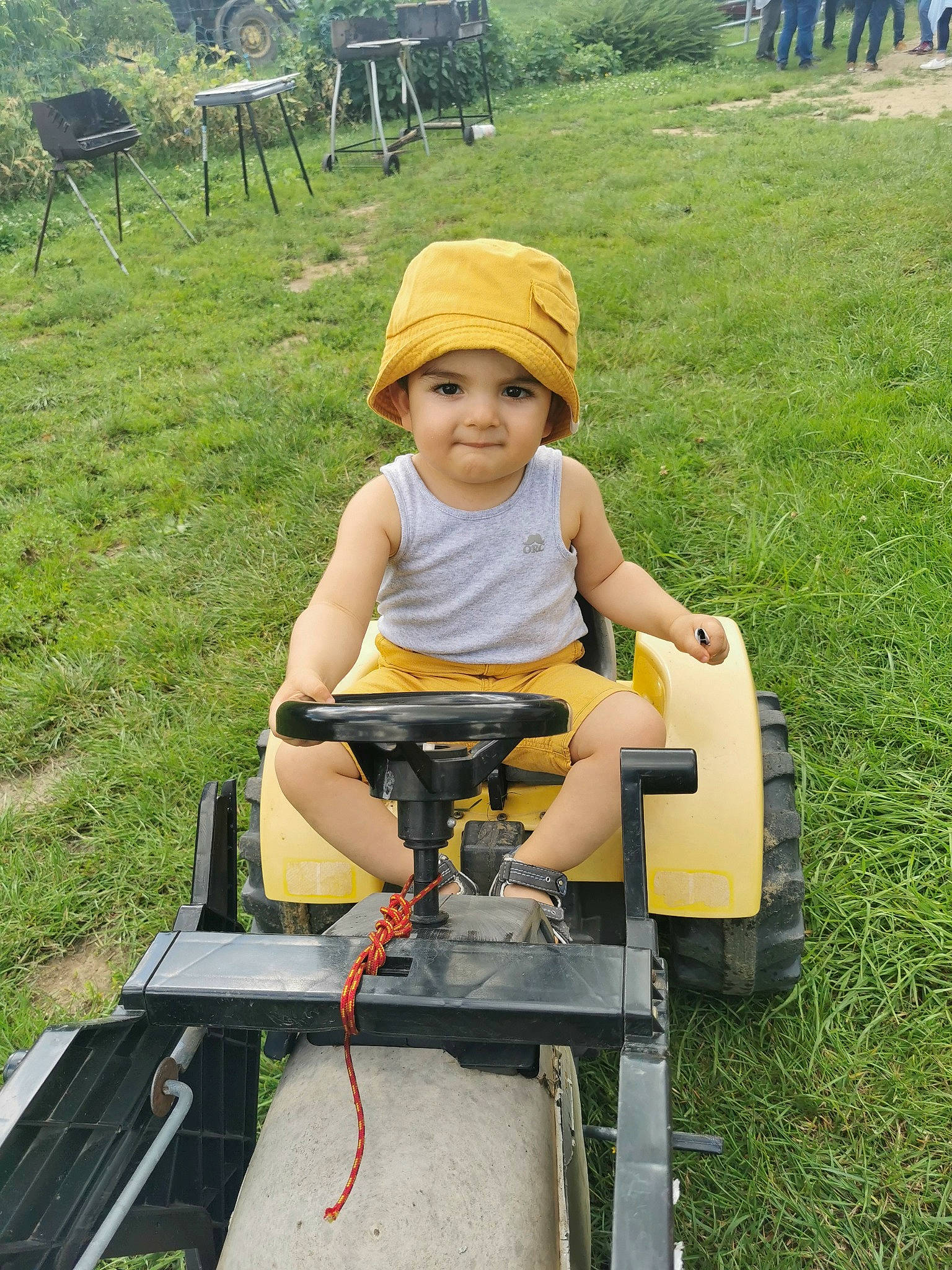 Neïl participe au concours pour gagner de l'argent avec cette photo : baby, baby_toddler_clothing, face, fun, grass, grassland, happy, headwear, joy, lawn, leisure, person, plant, recreation, riding_toy, shorts, sitting, smile, t_shirt, tire