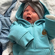 Zia is registered to the contest to win money with this photo: baby, infant, hoodie, headwrap, bow, blanket, bedding, blue, white, pattern, smiling, happy, cute, clothing, soft, indoors, person, child, face, portrait