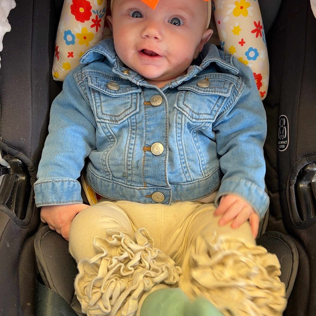 Zia joined the competition — help win amazing prizes! baby, baby_accessory, car_seat, child, clothing, comfort, cute, denim_jacket, floral_cushion, happy, indoor, infant, orange_bow, portrait, ruffled_pants, seated, smiling, snugride_snugfit_35, socks, wide_eyes