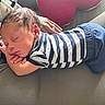 Elias joined the competition — help win amazing prizes! baby, newborn, sleeping, striped_clothing, blue_pants, couch, hand, heart_pillow, soft_light, indoor, cozy, peaceful, infant, child, person, portrait, resting, toddler, furniture, blanket