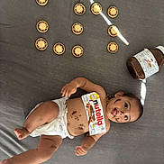 Sima a rejoint le concours — aidez-le/la à gagner de superbes lots ! baby, nutella, chocolate, cookies, diaper, bed, messy, playful, smiling, tongue_out, face_paint, jar, food, cute, child, happy, indoor, lying_down, fun, snack