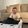 toddler, child, toy_car, indoor, smiling, happy, couch, living_room, clothing, person, seat, steering_wheel, furniture, cute, baby, young_child, fun, play, vehicle, car