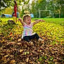 toddler, child, autumn, leaves, park, grass, sunlight, outdoor, play, joyful, smiling, nature, fall, tree, greenery, casual_clothing, happy, fun, daylight, young