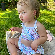 Skylar joined the competition — help win amazing prizes! baby, child, clothing, cute, daylight, fun, grass, greenery, hair, nature, outdoor, person, playful, portrait, sitting, summer, sunlight, swimsuit, toddler, towel