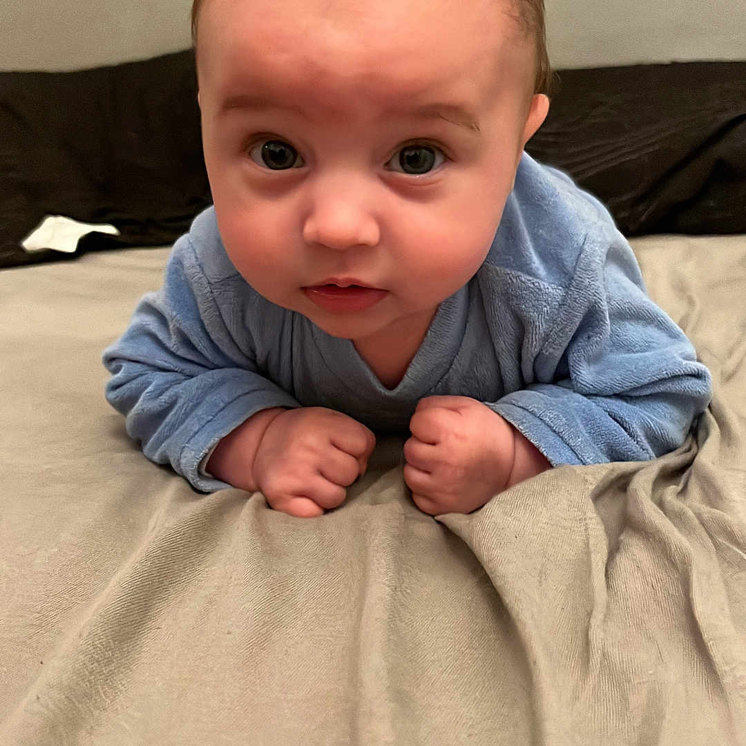 Alessyo a rejoint le concours — aidez-le/la à gagner de superbes lots ! baby, infant, blue_clothing, bed, blanket, curious, face, hands, lying_down, indoors, person, portrait, skin, young_child, head_up, wide_eyes, soft_lighting, cute, expression, toddler