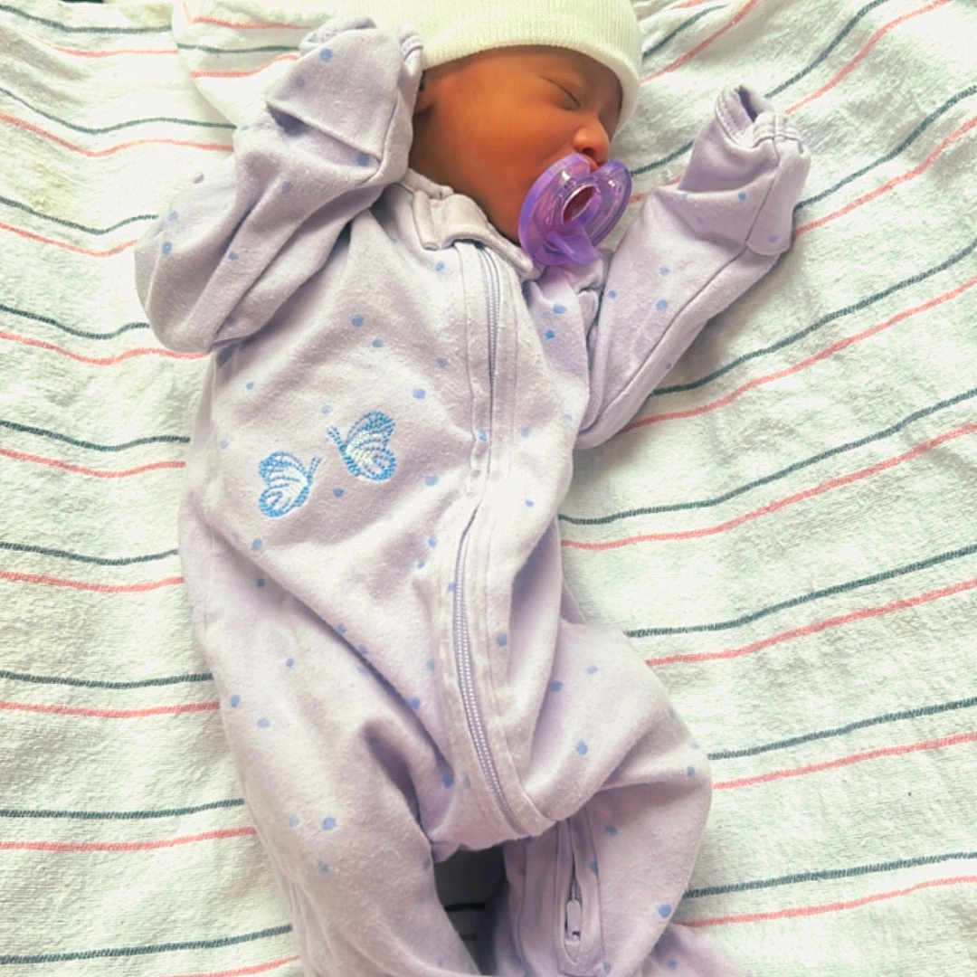 Yaniia is registered to the contest to win money with this photo: baby, blanket, child, closed_eyes, cozy, cute, footed_pajamas, hat, hospital, indoors, infant, lying_down, newborn, onesie, pacifier, peaceful, purple, sleeping, soft, striped_blanket