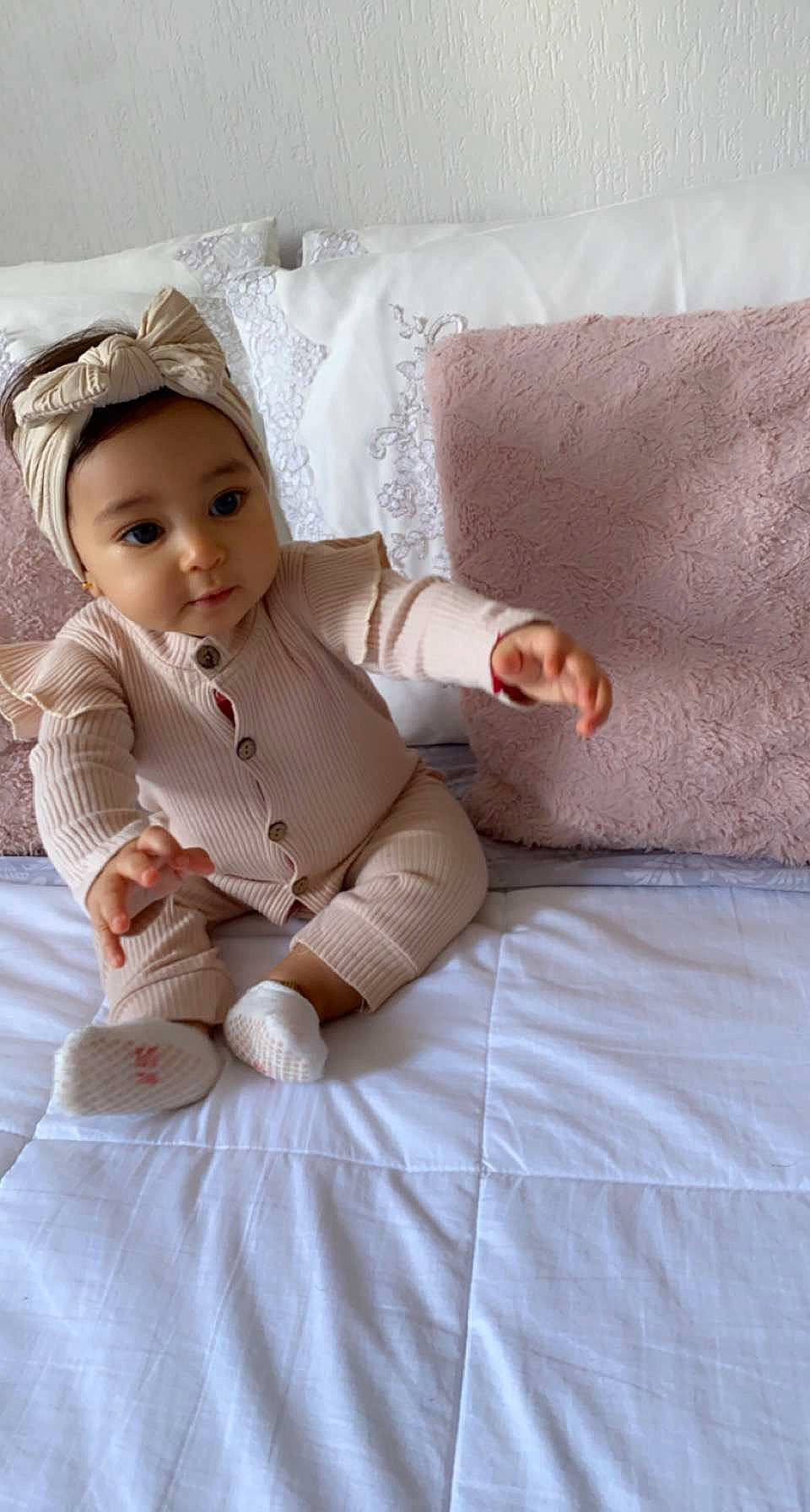 Ayline a rejoint le concours — aidez-le/la à gagner de superbes lots ! baby, baby_toddler_clothing, bedding, cap, child, comfort, dress, fashion_accessory, fur, happy, hat, headwear, human_leg, linens, peach, person, room, sitting, skin, sleeve