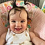 baby, baby_seat, bunny_pattern, cheerful, child, closeup, cute, floral_pattern, hair_bows, happy, indoor, infant, person, pigtails, portrait, seated, smile, teddy_bear_print, white_clothing, young_child