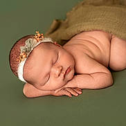 Hallie joined the competition — help win amazing prizes! newborn, baby, sleeping, headband, flower, green_background, blanket, skin, peaceful, cute, infant, portrait, soft_light, closeup, resting, hands, face, naked, lying_down, child