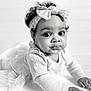 baby, child, infant, headband, bow, crawling, curly_hair, black_and_white, portrait, closeup, cute, expression, face, hands, long_sleeve, tulle_skirt, floor, indoor, soft_light, curious