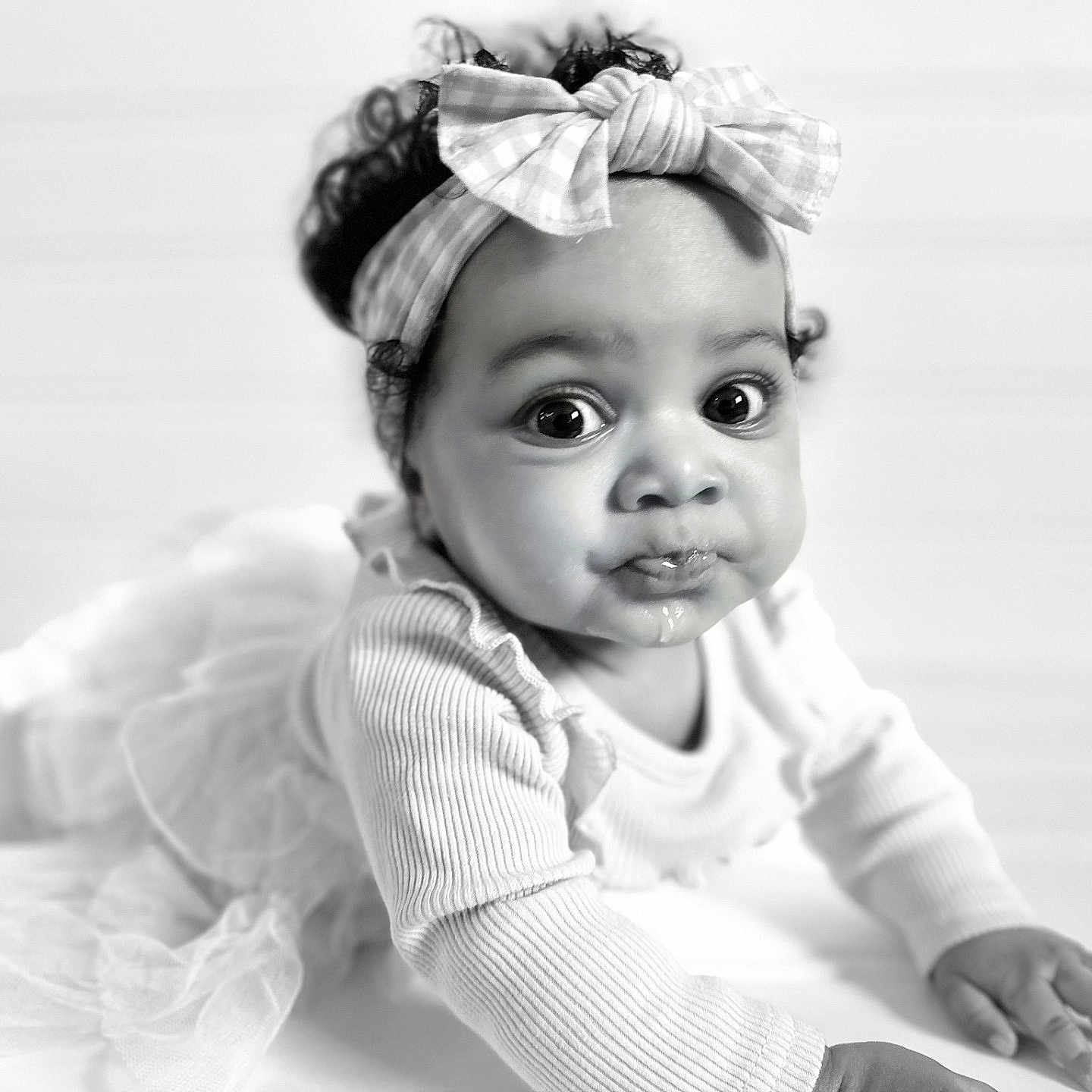 Kamiyah is registered to the contest to win money with this photo: baby, black_and_white, bow, child, closeup, crawling, curious, curly_hair, cute, expression, face, floor, hands, headband, indoor, infant, long_sleeve, portrait, soft_light, tulle_skirt