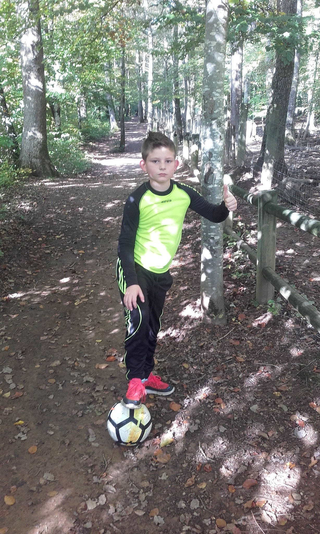 Logan participe au concours pour gagner de l'argent avec cette photo : ball, football, forest, grass, jungle, leisure, people_in_nature, person, plant, recreation, shorts, soccer, soccer_ball, soil, sports_equipment, t_shirt, terrestrial_plant, toddler, trail, tree