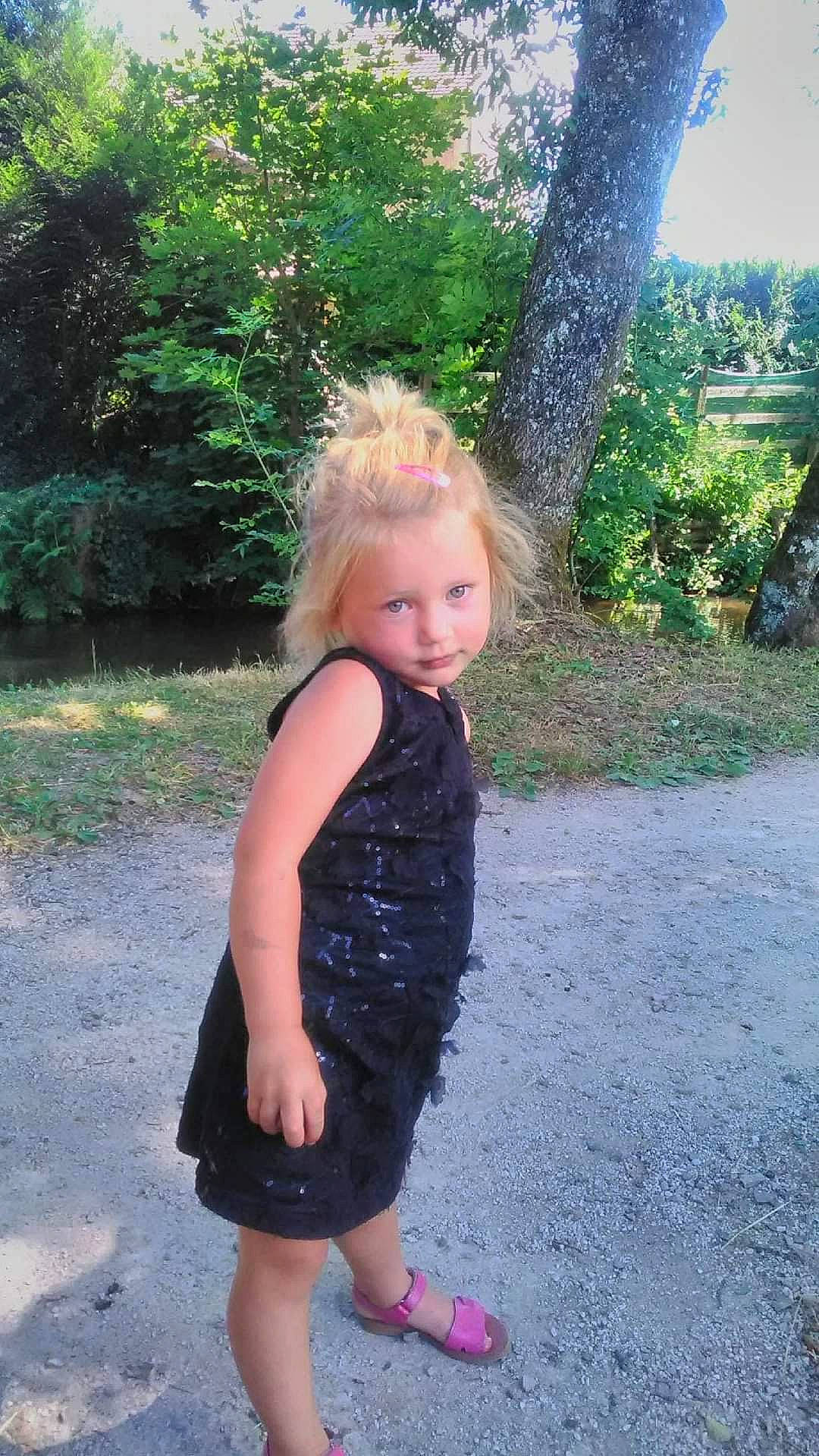 Djéna a rejoint le concours — aidez-le/la à gagner de superbes lots ! baby_toddler_clothing, blond, day_dress, dress, electric_blue, fun, garden, grass, happy, magenta, pattern, people_in_nature, person, plant, recreation, sleeve, smile, summer, toddler, tree