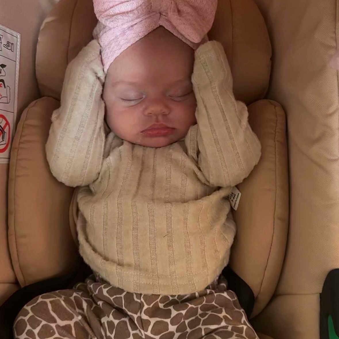 Talia-Rai is registered to the contest to win money with this photo: apparel, baby, bow, car_seat, child, cozy, cushion, cute, giraffe_print, headband, indoors, infant, pants, peaceful, person, resting, sleeping, soft_lighting, sweater, young