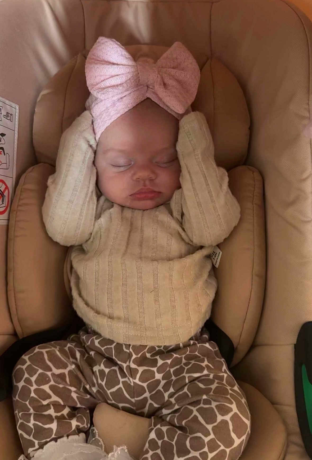 Talia-Rai is registered to the contest to win money with this photo: baby, sleeping, headband, bow, sweater, giraffe_print, pants, cushion, car_seat, infant, child, cute, cozy, resting, indoors, person, apparel, young, peaceful, soft_lighting
