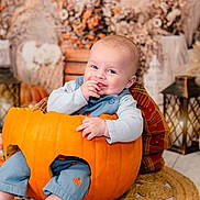 Jesse is registered to the contest to win money with this photo: baby, pumpkin, smiling, autumn, fall_decor, lantern, dried_flowers, cute, indoor, child, orange, plush, seasonal, festive, cozy, portrait, sitting, happy, clothing, floor