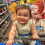 Wrenlee is registered to the contest to win money with this photo: baby, child, shopping_cart, store, grocery, smiling, face, hair, clothing, hand, shelf, product, tissue, package, blue, white, retail, infant, cute, person