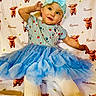 Alena joined the competition — help win amazing prizes! toddler, child, blue_tutu, headband, baby, striped_shirt, cute, blanket, pattern, animal_print, smiling, posing, indoor, soft_toys, clothing, fabric, playful, lying_down, young_child, happy