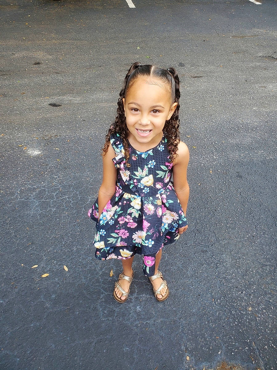 Sofia is registered to the contest to win money with this photo: asphalt, dress, electric_blue, flash_photography, foot, fun, gesture, grass, hairstyle, happy, human_leg, joy, mammal, people_in_nature, person, road, road_surface, smile, standing, sunlight