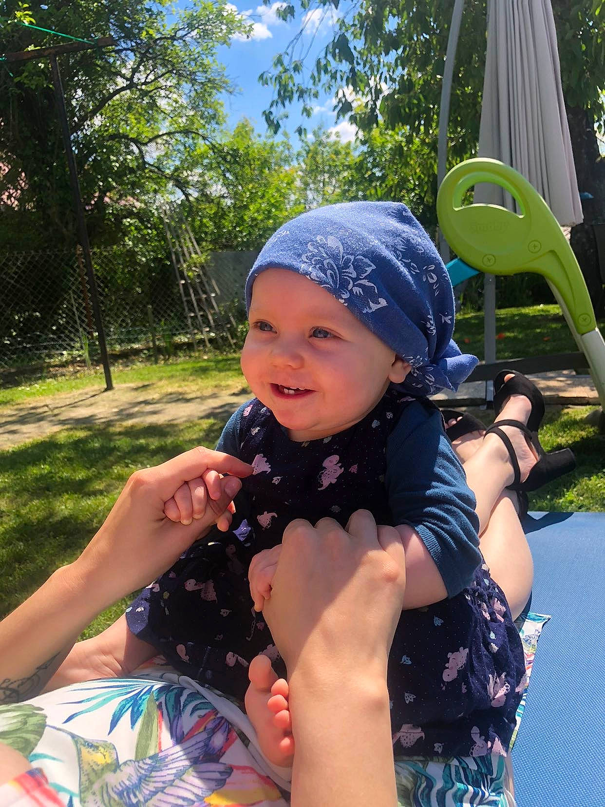 Faustine participe au concours pour gagner de l'argent avec cette photo : baby, baby_toddler_clothing, cap, electric_blue, fun, grass, happy, headwear, human_leg, joy, lap, leisure, person, personal_protective_equipment, plant, recreation, sitting, sky, smile, summer