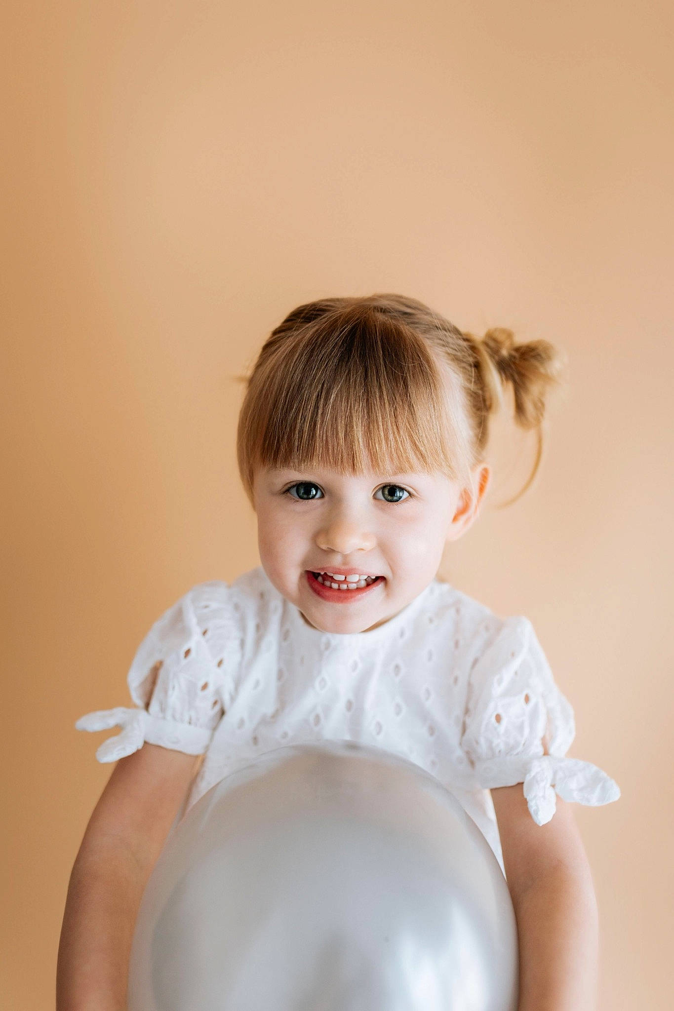 Chloé participe au concours pour gagner de l'argent avec cette photo : baby, baby_toddler_clothing, cheek, chin, dress, eye, eyebrow, flash_photography, gesture, happy, human_body, iris, joy, lip, neck, nose, person, shoulder, skin, sleeve