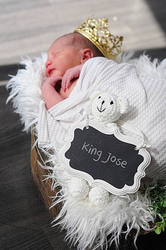 King is registered to the contest to win money with this photo: baby, baby_products, baby_toddler_clothing, cap, costume_hat, event, fashion_accessory, feather, font, fur, fur_clothing, grass, hair_accessory, happy, hat, headgear, headpiece, jewellery, person, toddler