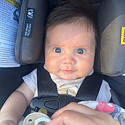 Liam is registered to the contest to win money with this photo: baby, infant, car_seat, child, pacifier, blanket, hand, straps, face, eyes, clothing, safety, seat_belt, cute, expression, indoor, head_support, skin, person, newborn