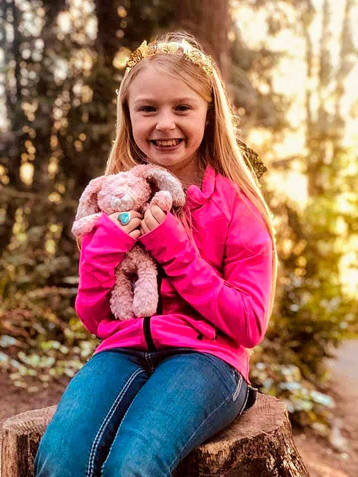 Caylee is registered to the contest to win money with this photo: botany, clothing, eye, fawn, fun, grass, hairstyle, happy, head, joy, leisure, mammal, people_in_nature, person, plant, smile, standing, summer, toy, tree