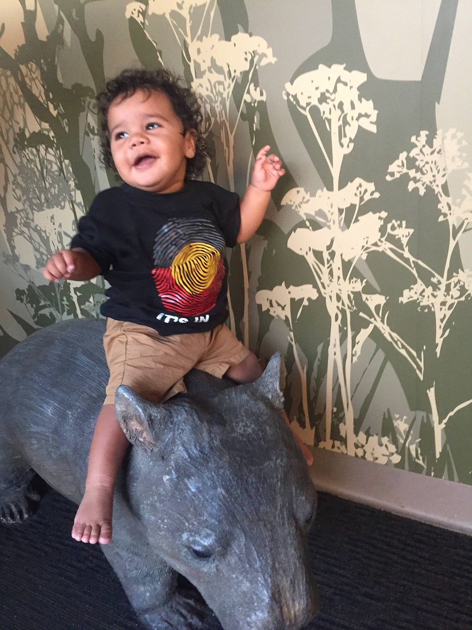 Jaccob is registered to the contest to win money with this photo: art, child, floral_design, fun, leg, person, plant, sitting, t_shirt, toddler, world