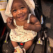 Eden is registered to the contest to win money with this photo: baby, child, smiling, dress, hat, stroller, footwear, infant, cute, happy, portrait, indoors, seat, person, fashion, accessory, childrens_clothing, closeup, baby_shoes, sitting