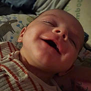 Henry is registered to the contest to win money with this photo: baby, smile, close_up, face, infant, sleeping, striped_clothing, pillow, animal_print, cute, child, portrait, young_child, soft_lighting, indoor, happy, peaceful, person, head, toddler