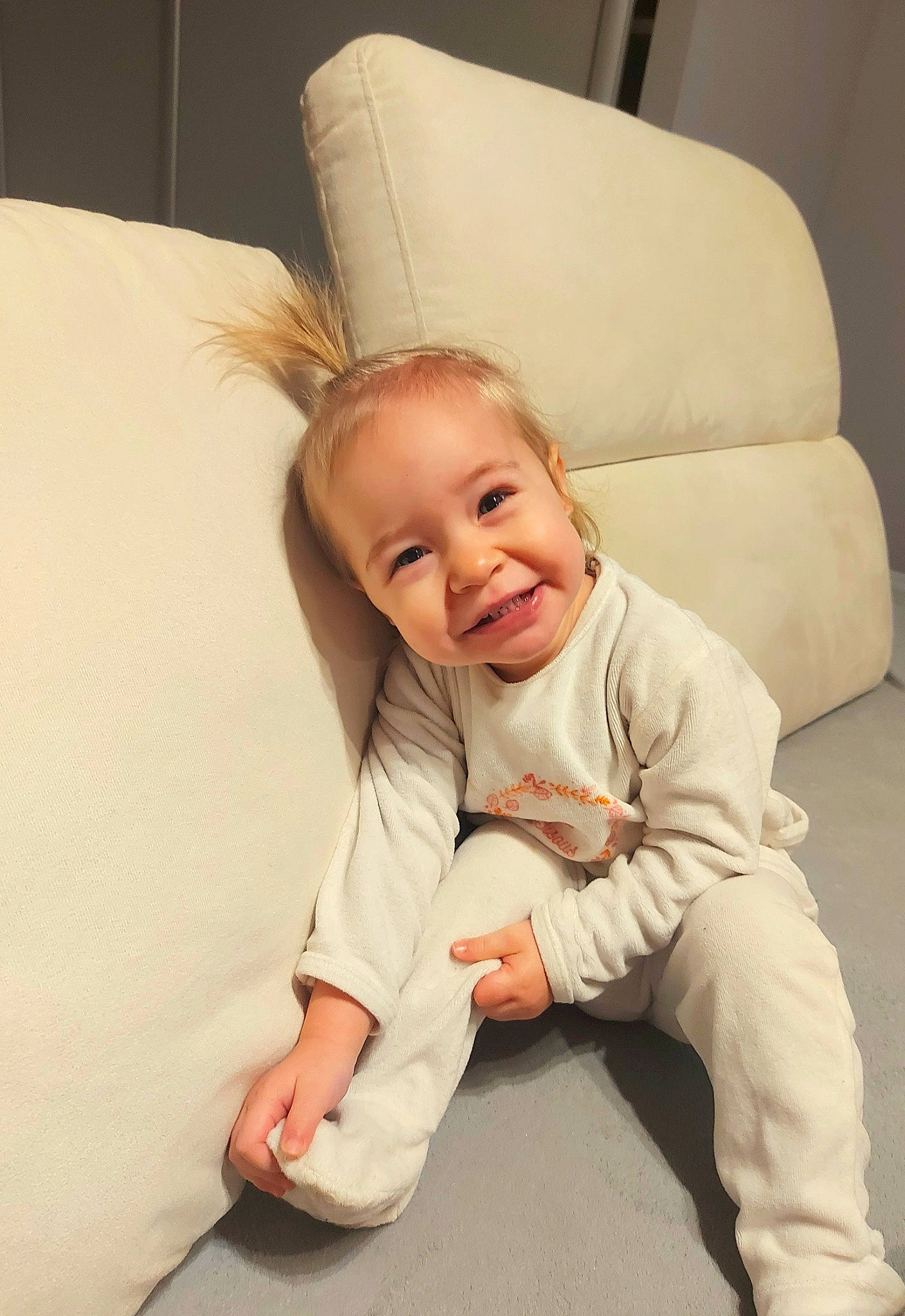 Thalia participe au concours pour gagner de l'argent avec cette photo : baby_toddler_clothing, barefoot, cheek, child, comfort, couch, eye, floor, flooring, foot, gesture, hair, happy, head, joy, linens, person, sitting, sleeve, smile