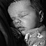 baby, sleeping, infant, black_and_white, close_up, face, soft_lighting, peaceful, cozy, child, portrait, newborn, clothing, pattern, floral, cute, resting, head, skin, young