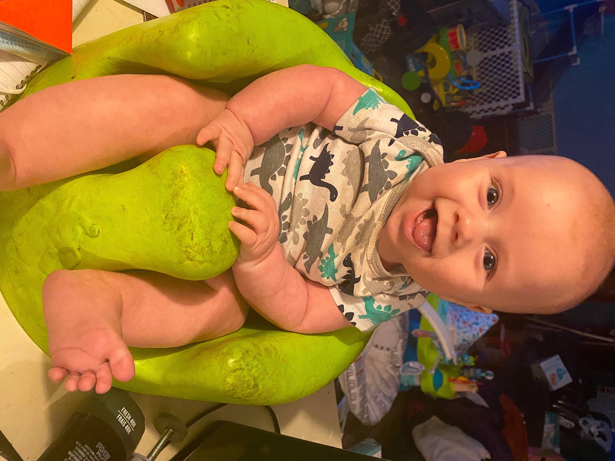 Flynn is registered to the contest to win money with this photo: baby, cheek, child, finger, fun, green, happy, headgear, human_body, human_leg, leisure, mouth, muscle, nail, person, personal_protective_equipment, skin, smile, thigh, toddler