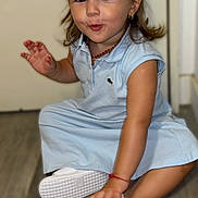 Alessia a rejoint le concours — aidez-le/la à gagner de superbes lots ! child, toddler, girl, blue_dress, pigtails, hair_bows, white_shoes, floor, indoor, smiling, cute, playful, expression, sitting, person, earrings, bracelet, necklace, happy, young