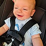 baby, car_seat, child, smiling, harness, seatbelt, infant, blue_shirt, light_hair, warning_label, safety, cute, portrait, closeup, happy, child_seat, person, straps, young_child, infancy