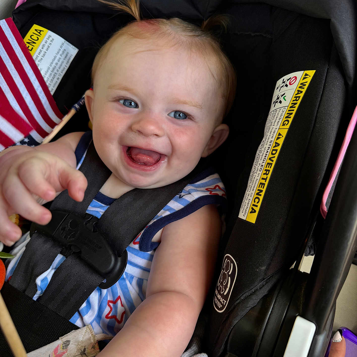 Everleigh Mae joined the competition — help win amazing prizes! baby, blue_eyes, car_seat, child, closeup, clothing, cute, flag, hand, happy, indoor, infant, joyful, person, pigtails, portrait, safety_harness, seat, smiling, striped_shirt