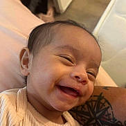 Arely is registered to the contest to win money with this photo: baby, smiling, face, closeup, tattoo, arm, person, happy, skin, infant, portrait, indoors, child, apparel, sleeve, human, cute, expression, joy, young