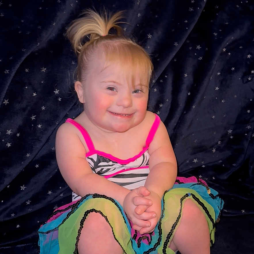 Jean Grey joined the competition — help win amazing prizes! baby, barefoot, child, clothing, colorful_dress, cute, fashion, fun, happy, indoors, person, playful, pony_tail, portrait, sitting, smiling, starry_background, studio, toddler, young