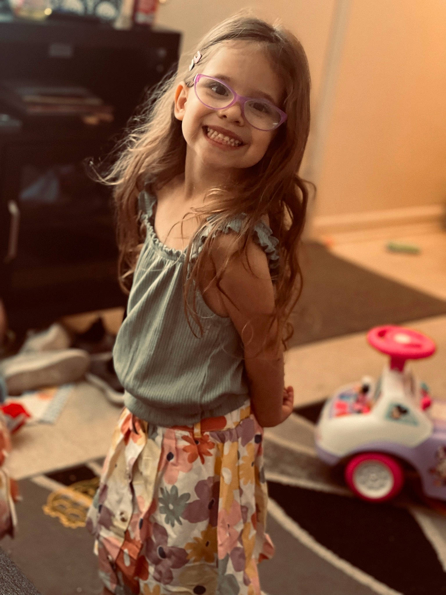 Addilyn is registered to the contest to win money with this photo: beauty, blond, brown_hair, child, eyewear, facial_expression, fashion_design, flooring, fun, hair, happy, joy, peach, person, skin, sleeve, smile, t_shirt, toddler, toy